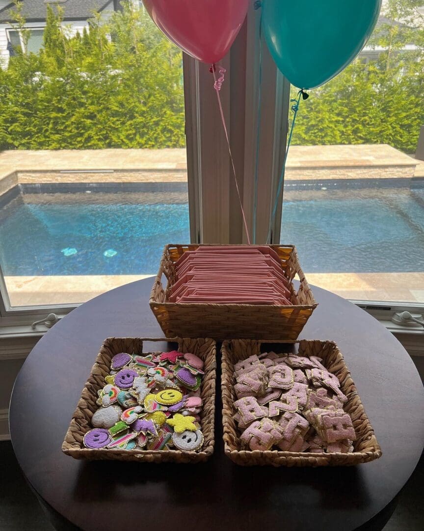Two baskets of cookies on a table in front of a window.