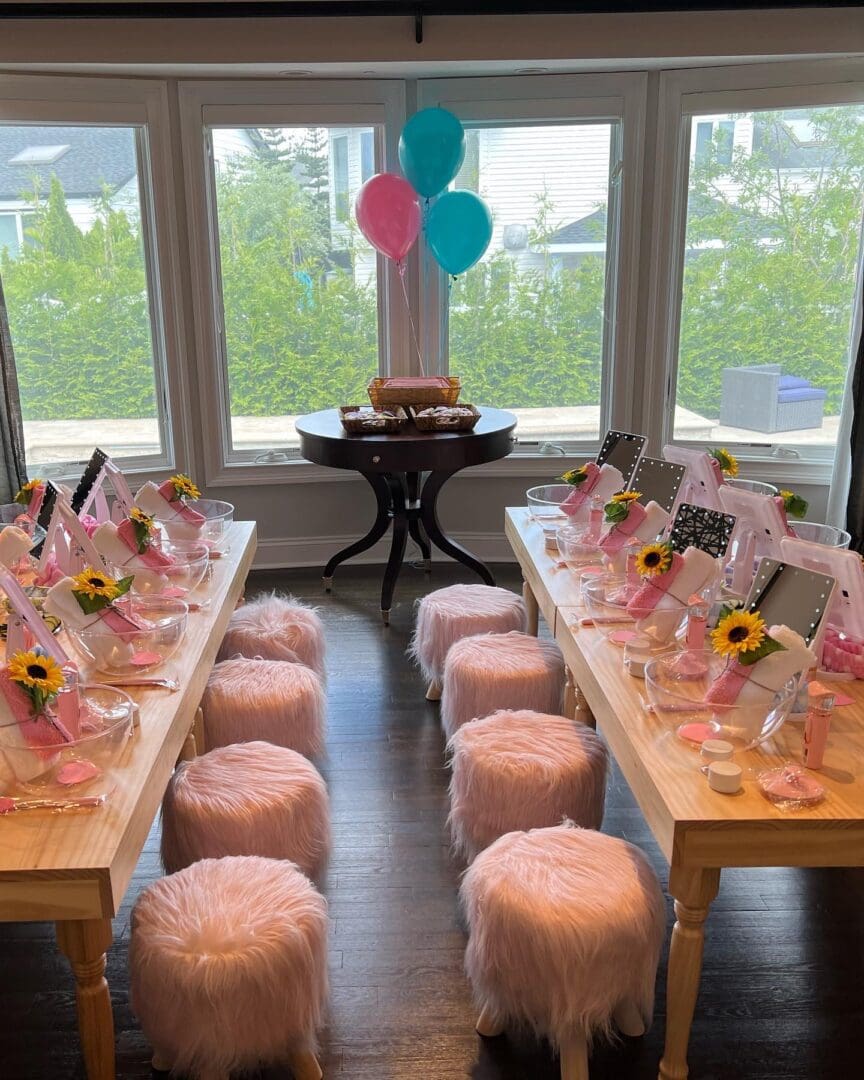 A room filled with pink and yellow balloons and stools.