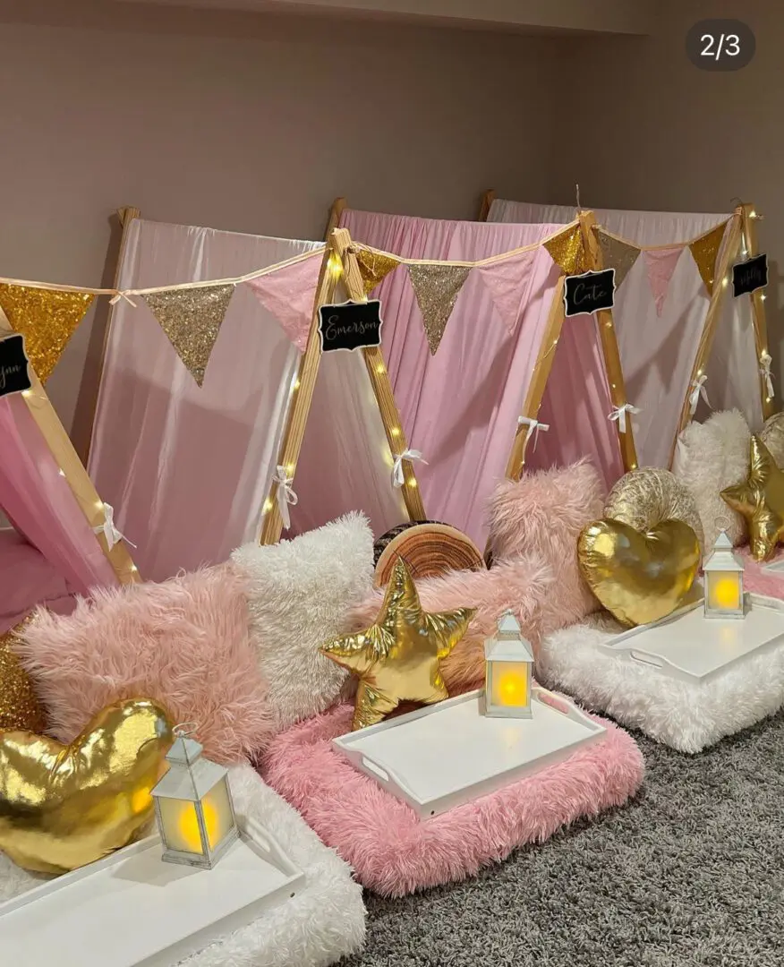 Pink and gold teepee tents with pillows and blankets.