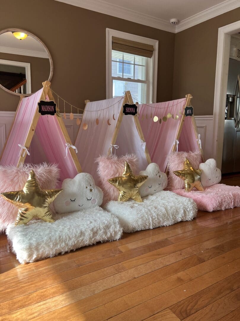 Three pink and gold teepees in a living room.