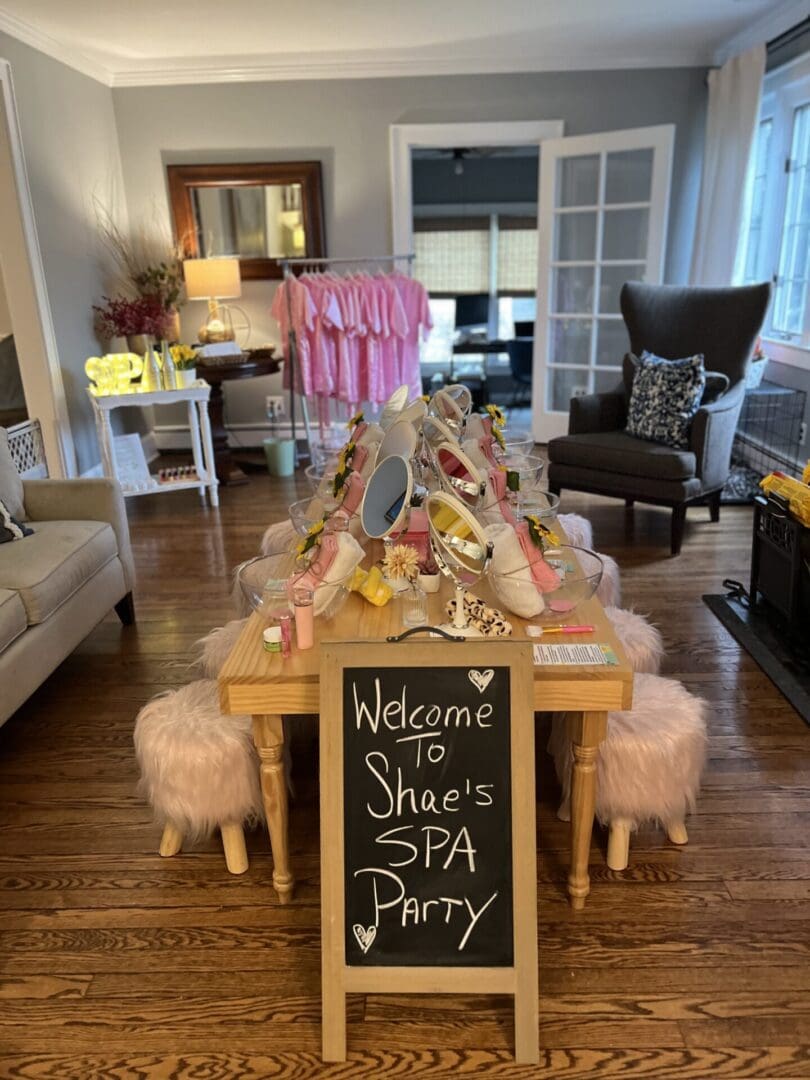 A living room with a table and chairs and a sign that says welcome shoe's party.